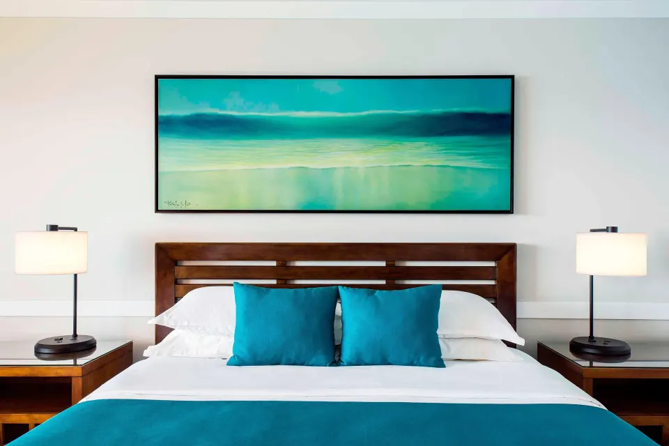 Moana Oceanfront king bed with teal accents at Sheraton Maui Resort & Spa.