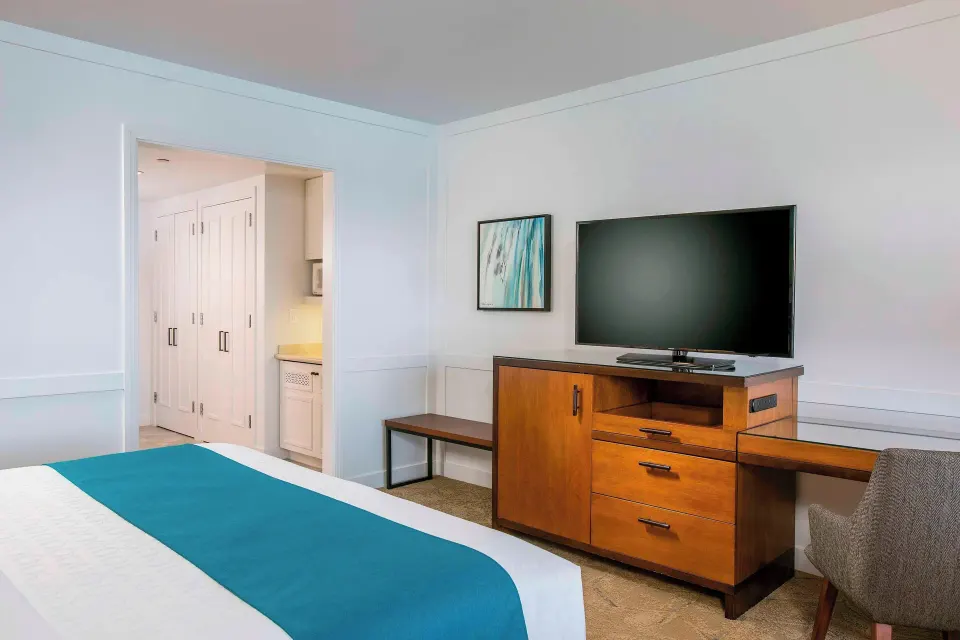 Moana Oceanfront room with bed, TV console, desk, and closet entry at Sheraton Maui Resort & Spa.