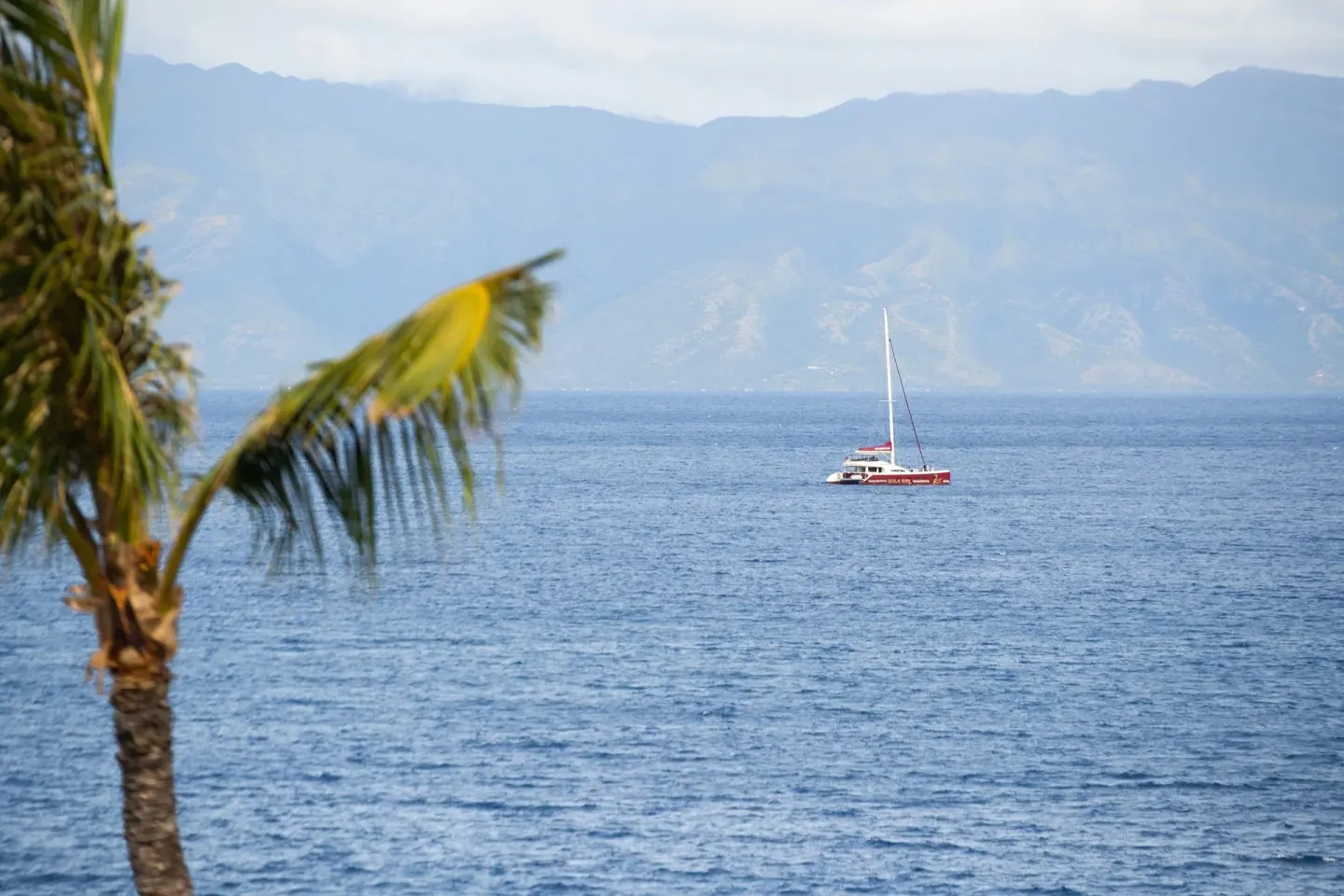 Ocean view with a sailboat and distant mountains from Sheraton Maui Resort & Spa.