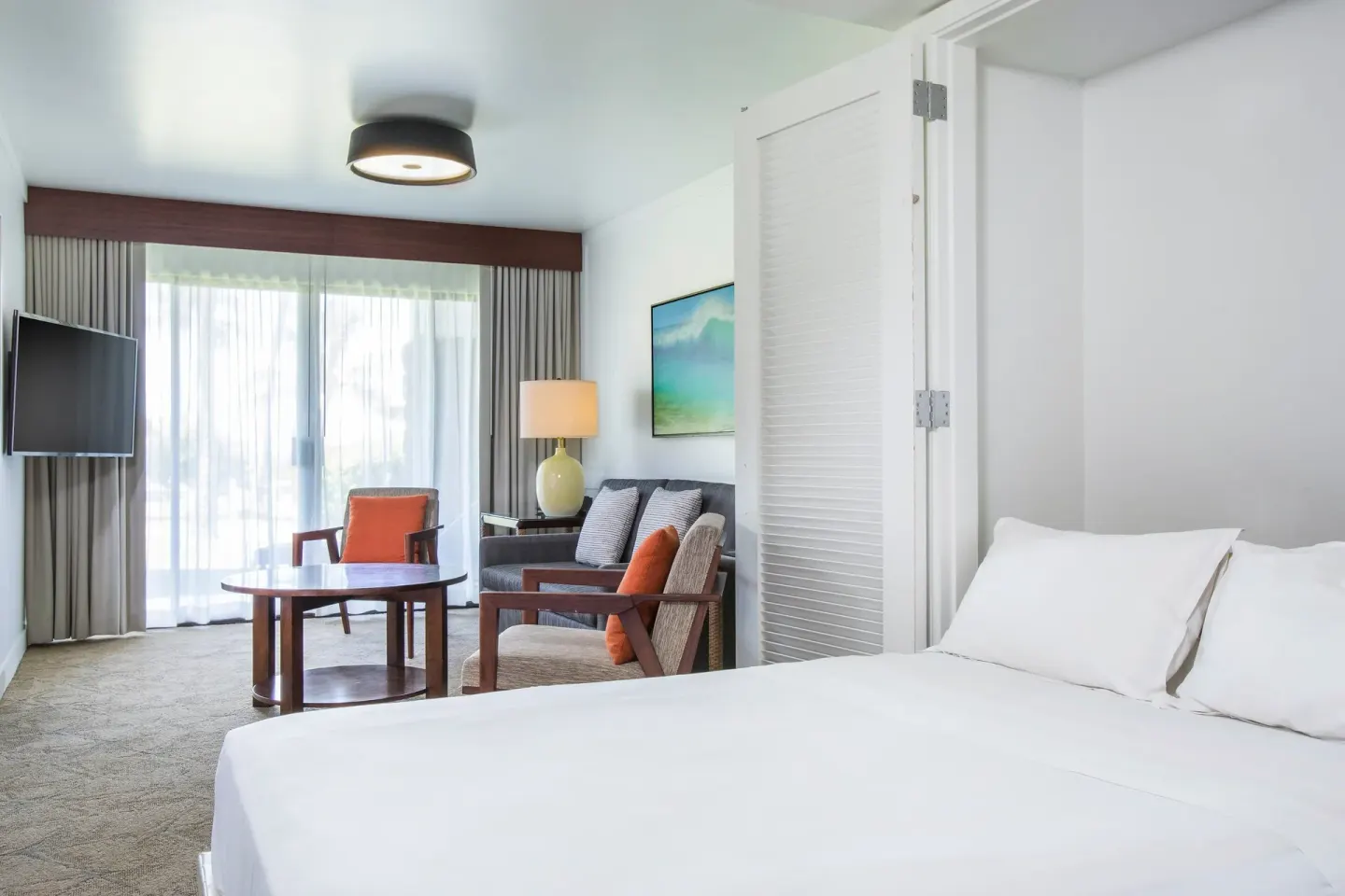 Ohana Suite Murphy bed area with seating and balcony doors at Sheraton Maui Resort & Spa.