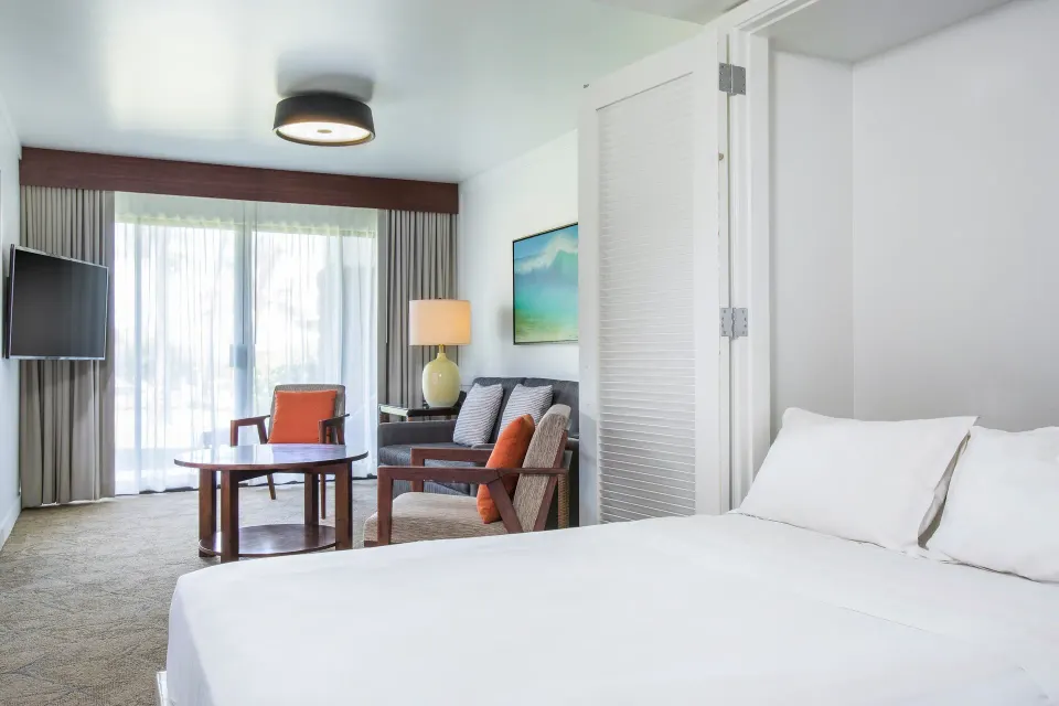 Ohana Suite Murphy bed area with seating and balcony doors at Sheraton Maui Resort & Spa.