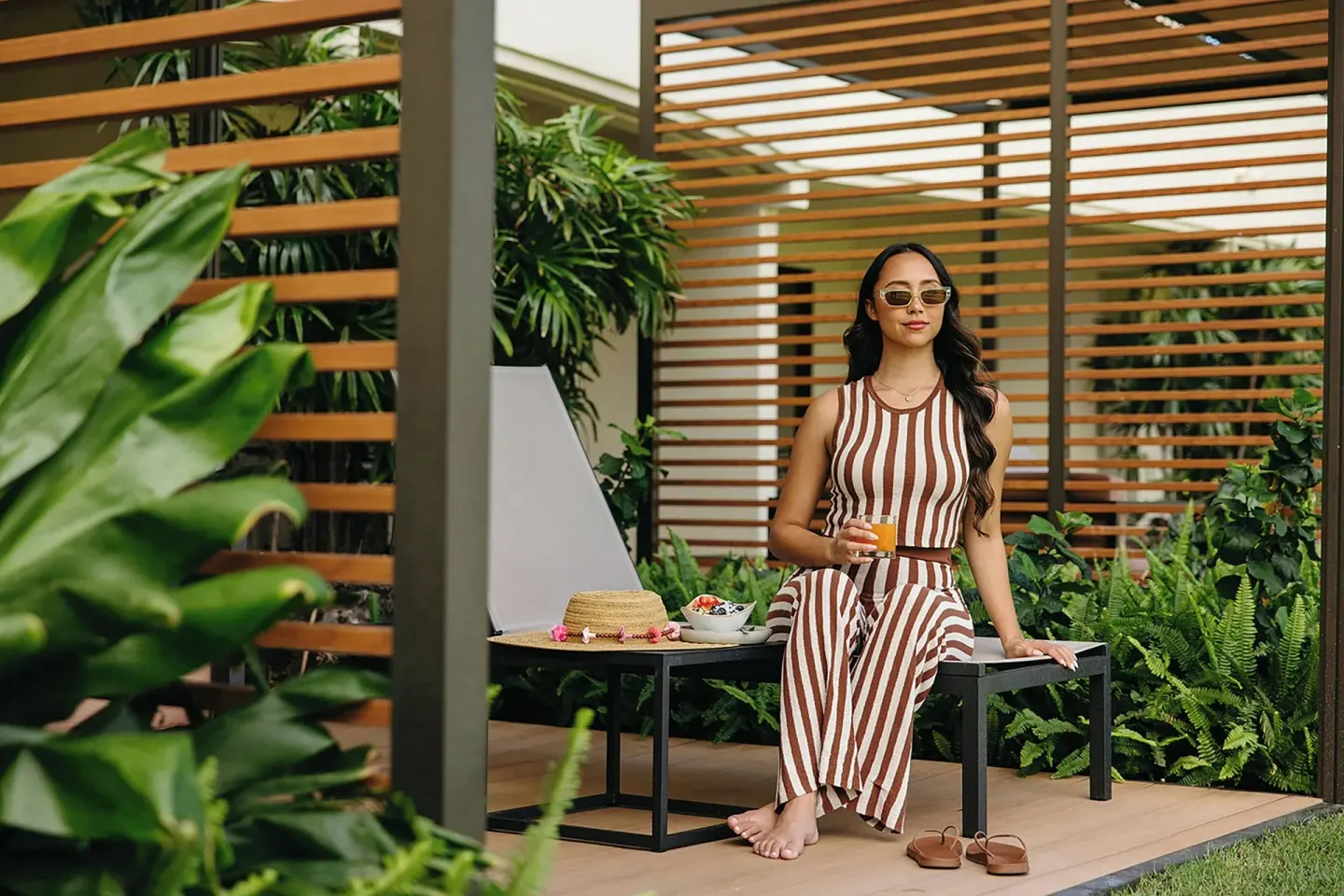 Guest seated with a drink on a Premium Lanai patio at Sheraton Maui Resort & Spa.