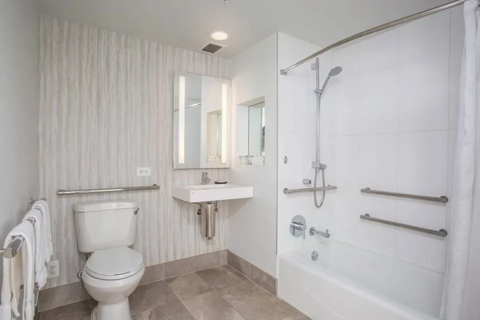 Hearing accessible bathroom with grab bars in a guest room at Sheraton Maui Resort & Spa.
