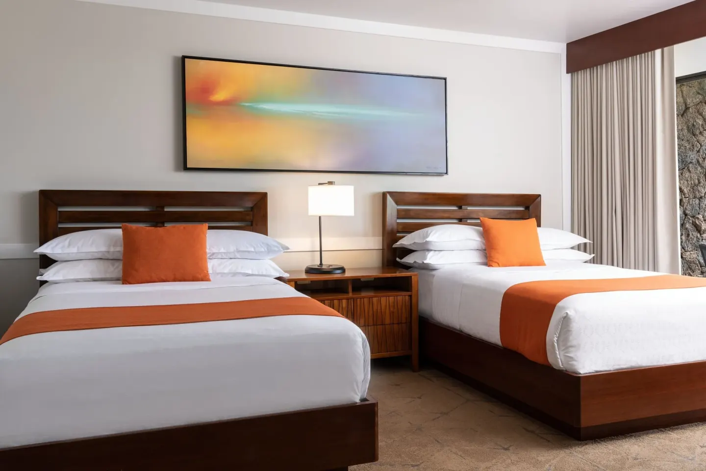 Two queen beds with orange accents in a Resort View room at Sheraton Maui Resort & Spa.