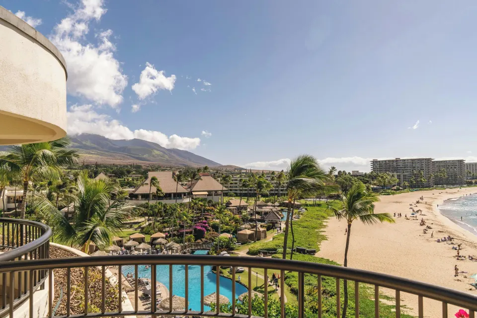 Suite balcony view of pool, beach, and mountains at Sheraton Maui Resort & Spa.