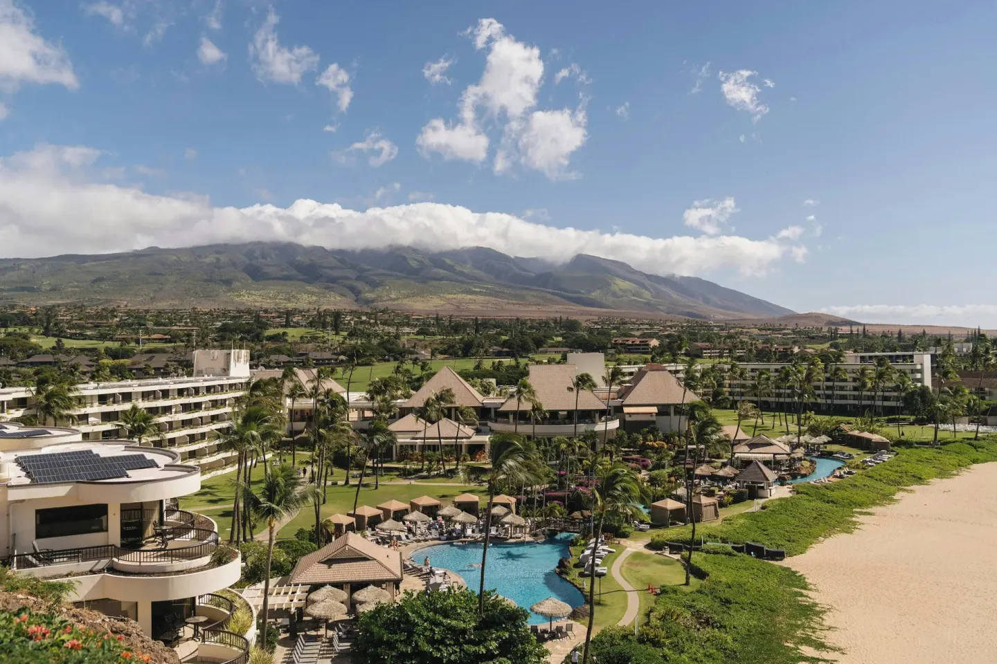 Beachfront resort grounds, pool, beach, and mountains at Sheraton Maui Resort & Spa.