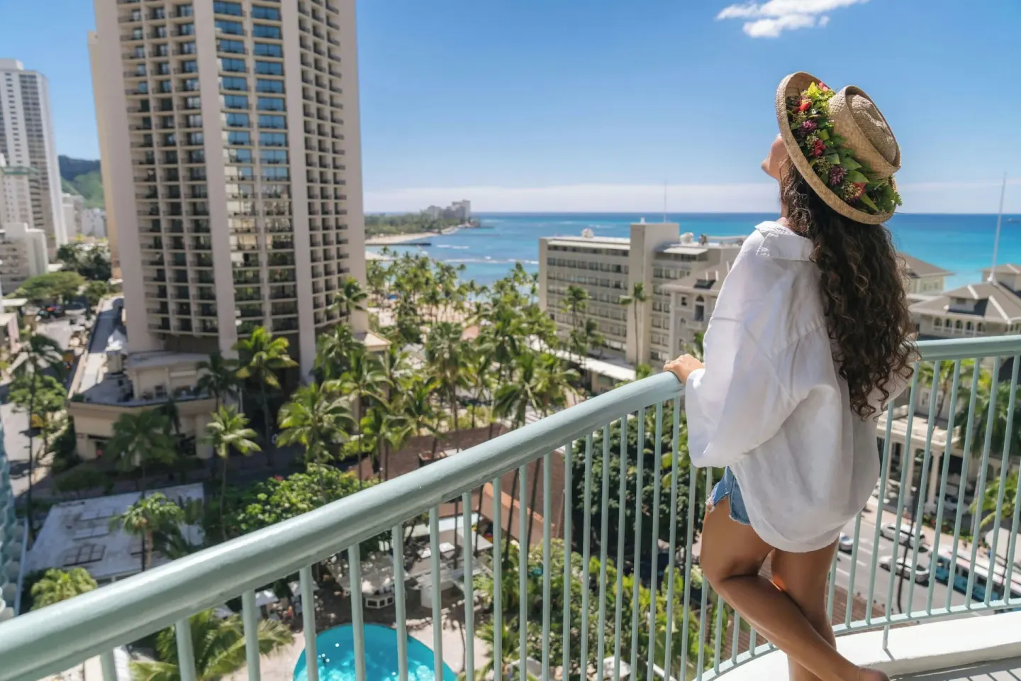 Guest standing on a high balcony with Waikiki and ocean views at Sheraton Princess Kaiulani.
