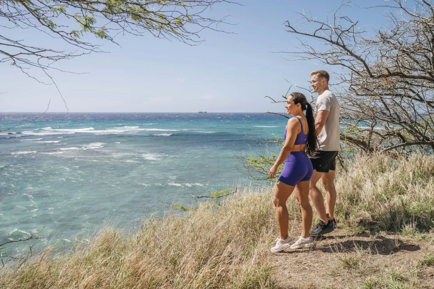 Two guests look out over the ocean from a coastal trail near Sheraton Princess Kaiulani.