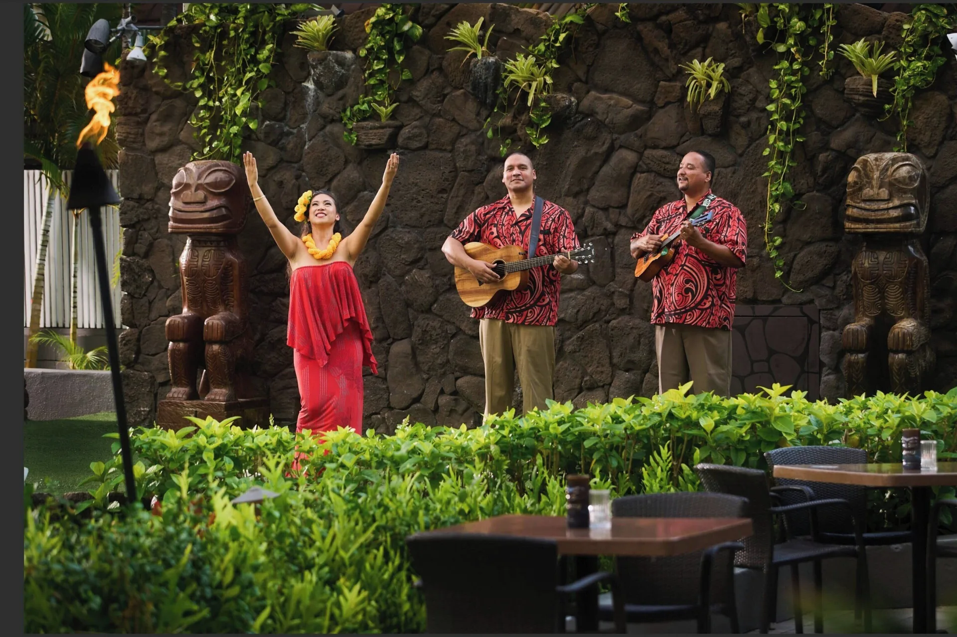 A hula dancer and two musicians perform outdoors at Sheraton Princess Kaiulani.