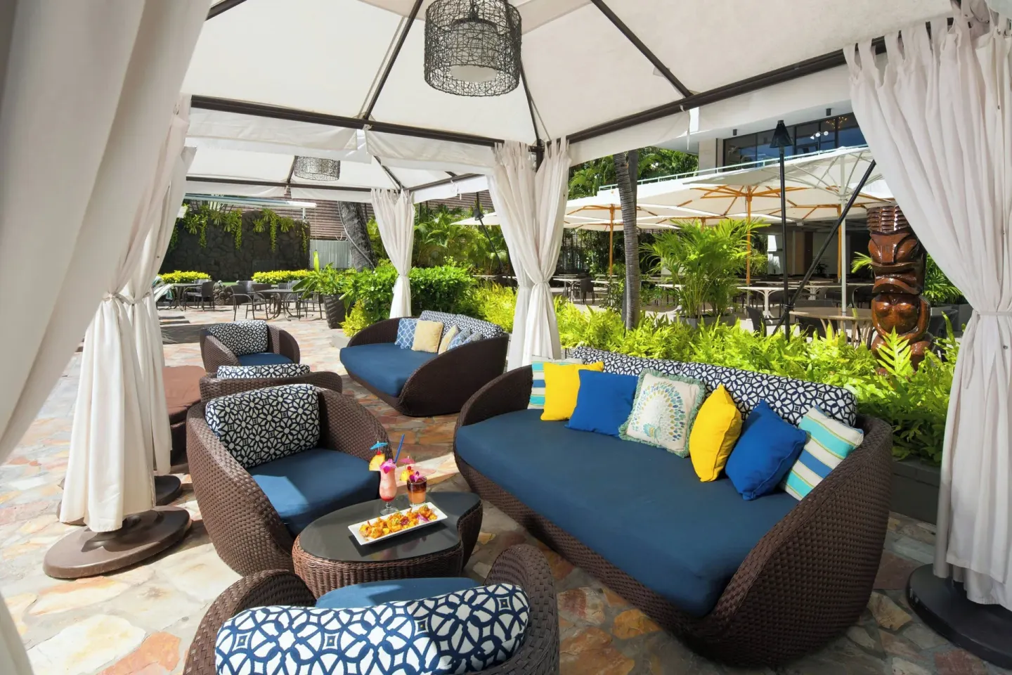 Shaded poolside cabana seating with sofas and drinks at Sheraton Princess Kaiulani.
