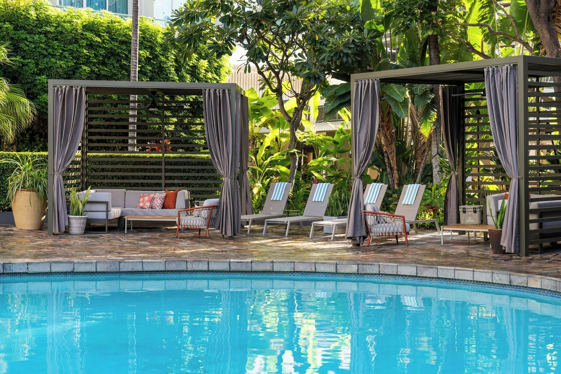 Poolside cabanas and lounge chairs line the pool at Sheraton Princess Kaiulani.