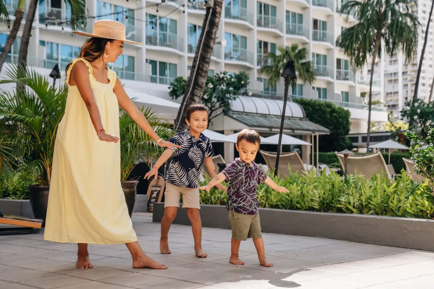 A woman and two children walk on a terrace at Sheraton Princess Kaiulani.