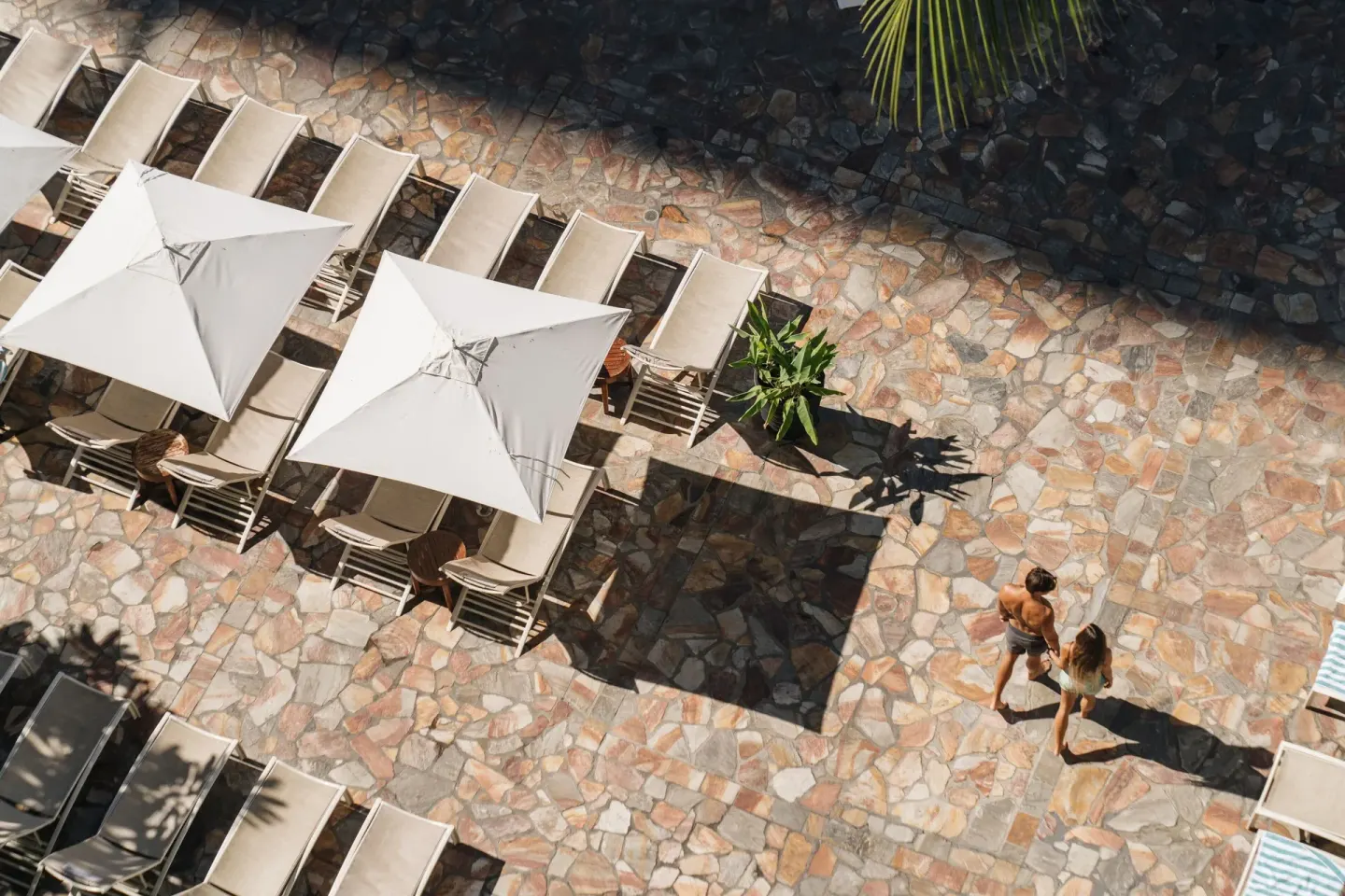 Overhead view of the stone pool deck with loungers and umbrellas at Sheraton Princess Kaiulani.