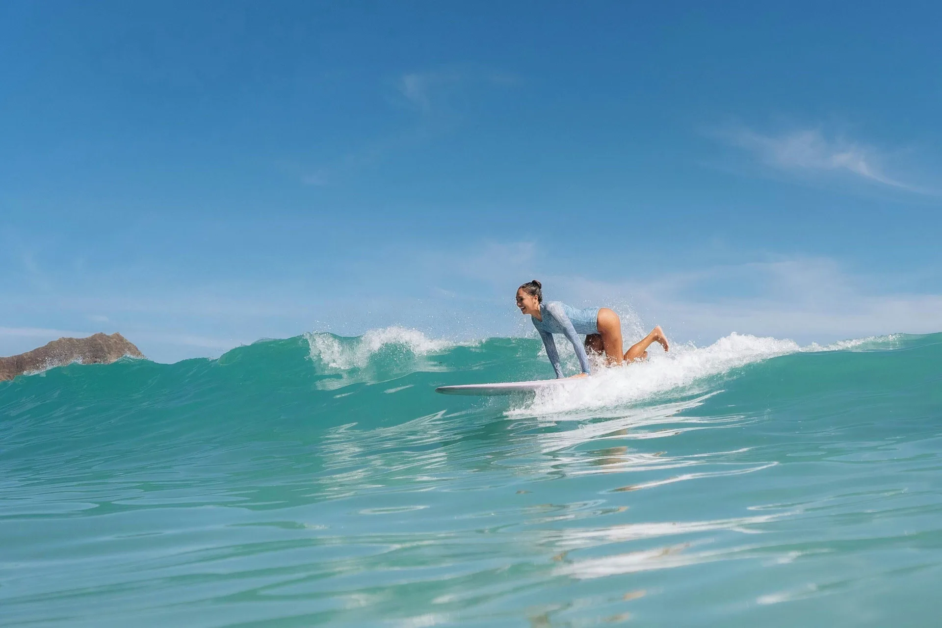 Surfer rides a small wave off Waikiki near Sheraton Princess Kaiulani.