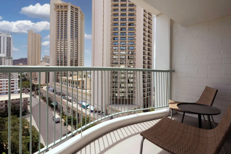 Kaiulani balcony with chairs and city high-rise views at Sheraton Princess Kaiulani.