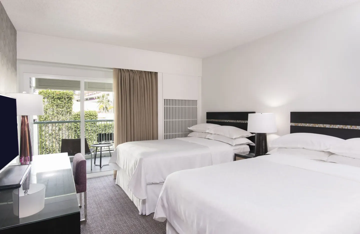 Kaiulani guest room with two beds and balcony seating at Sheraton Princess Kaiulani.