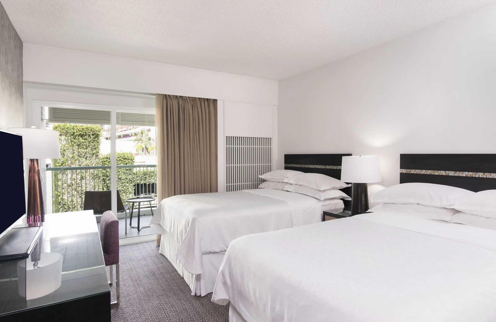 Kaiulani guest room with two beds and balcony seating at Sheraton Princess Kaiulani.