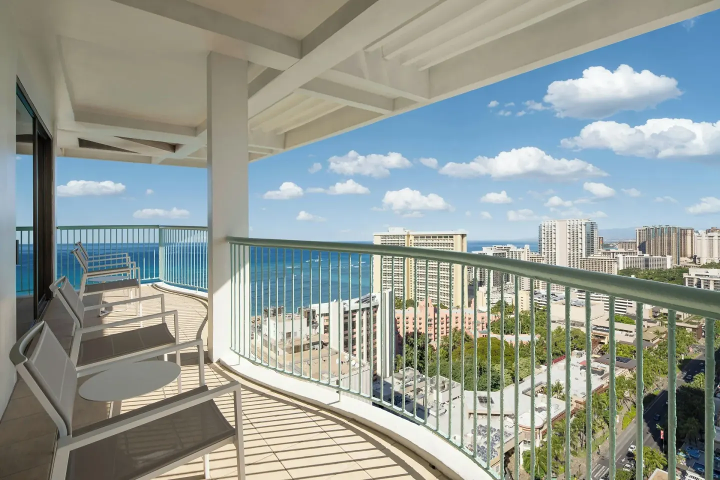 Renovated Corner Jr. Suite balcony at Sheraton Princess Kaiulani with seating and city and ocean views.