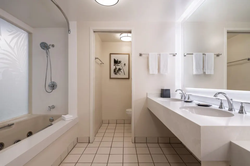 Renovated Corner Jr. Suite bathroom at Sheraton Princess Kaiulani with tub, shower, vanity, and towels.