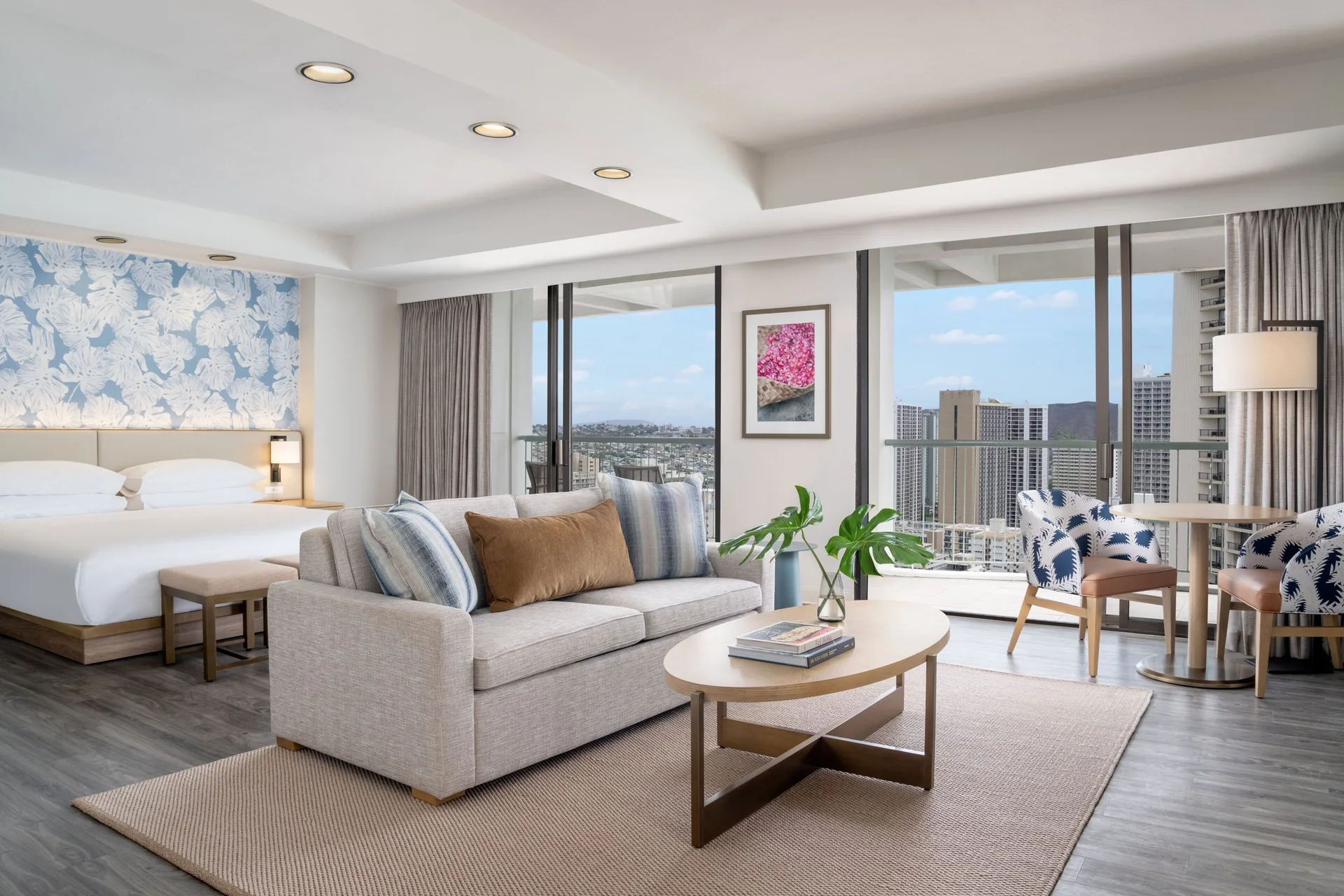 Renovated Corner Jr. Suite living and king bed area at Sheraton Princess Kaiulani with balcony views.