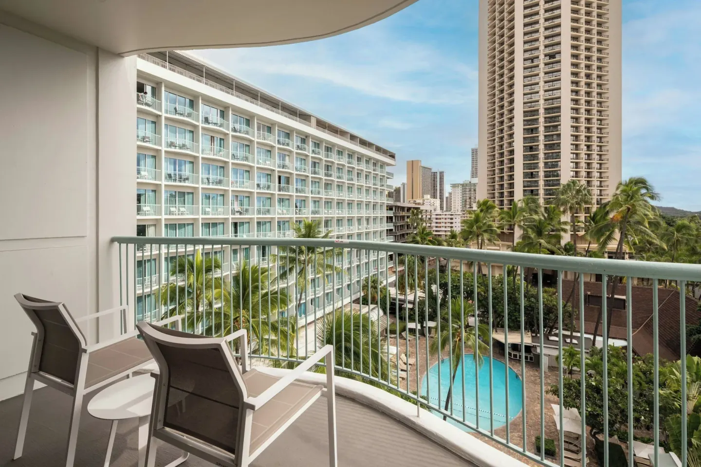 Balcony chairs overlook the pool and city towers at Sheraton Princess Kaiulani.