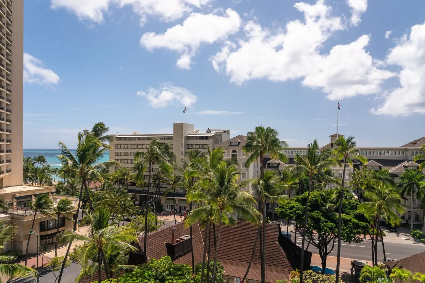 Pool View room outlook at Sheraton Princess Kaiulani with palms, Waikiki buildings, and ocean glimpse.