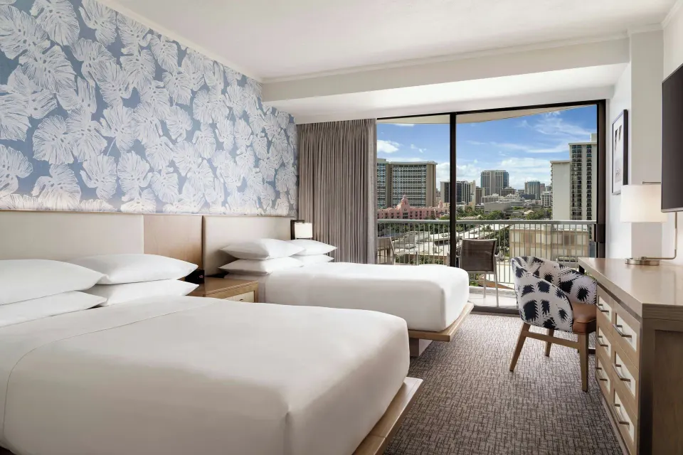 Standard Room with two beds, balcony, and city outlook at Sheraton Princess Kaiulani.