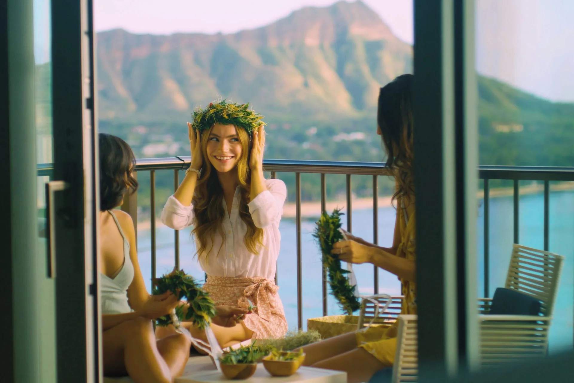 Guests make flower crowns on a balcony with Diamond Head views at Sheraton Waikiki Beach Resort.