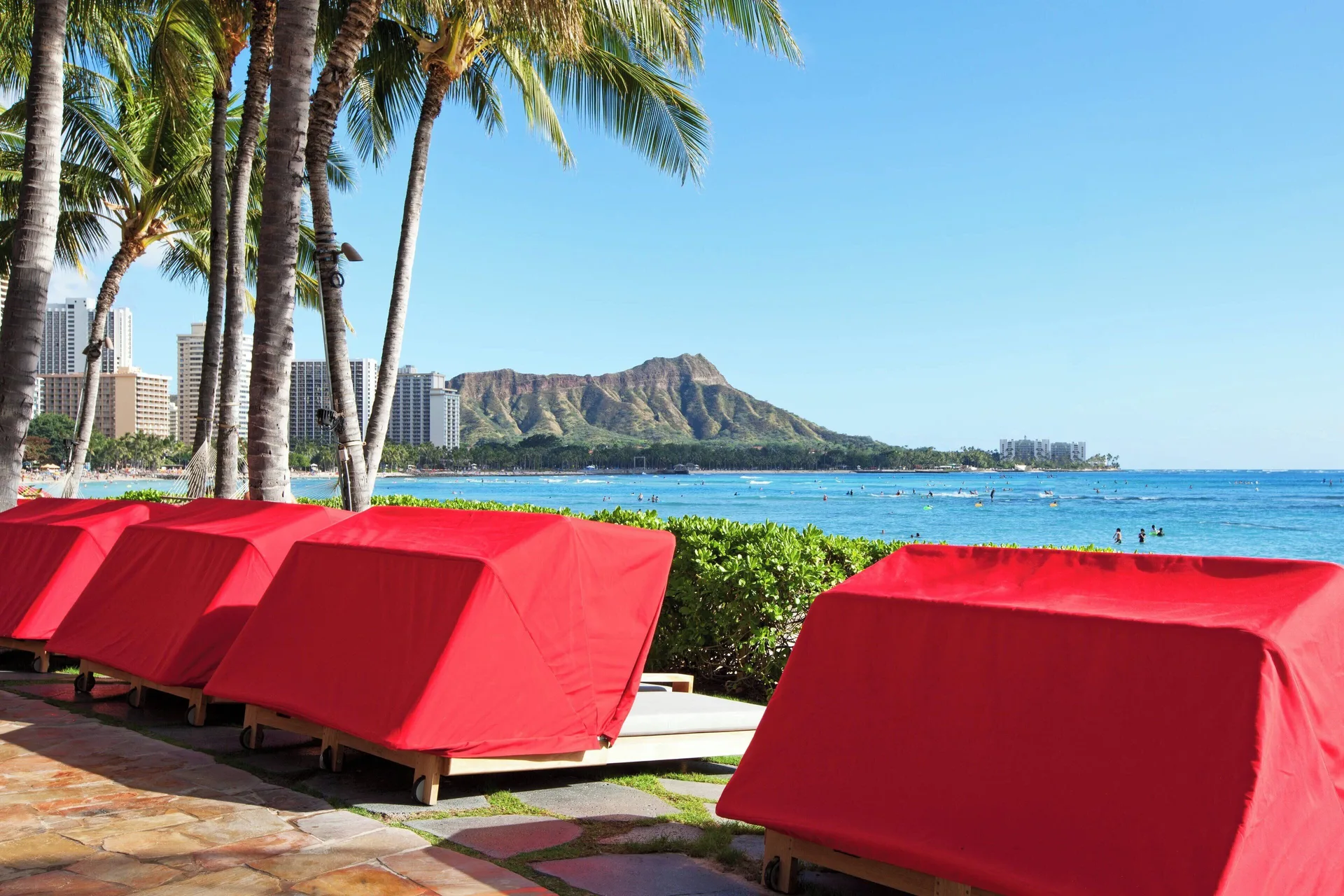Red beach cabanas facing Waikiki Beach and Diamond Head at Sheraton Waikiki Beach Resort.
