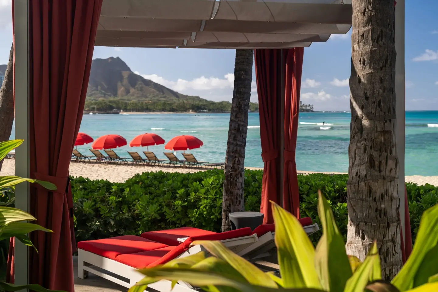 Shaded red cabana beside Waikiki Beach at Sheraton Waikiki Beach Resort.