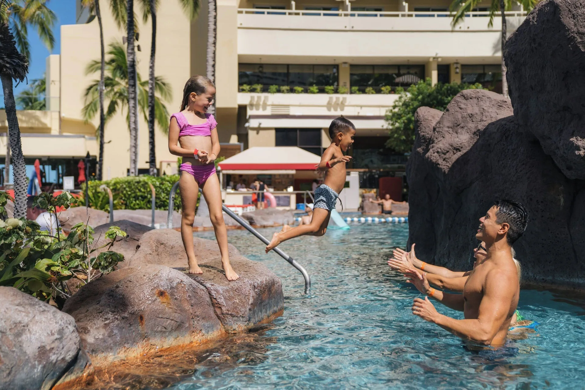 Children playing in a rock-lined pool at Sheraton Waikiki Beach Resort.
