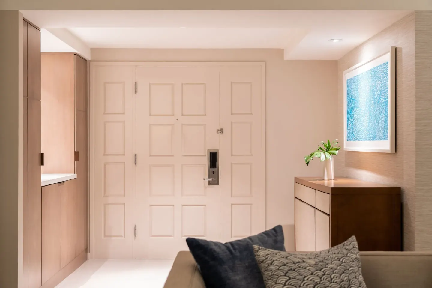 Guest room entry with paneled door and dresser at Sheraton Waikiki Beach Resort.