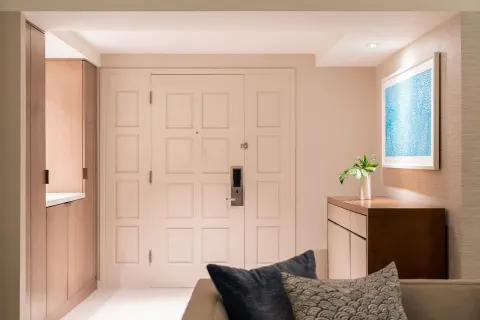 Guest room entry with paneled door and dresser at Sheraton Waikiki Beach Resort.