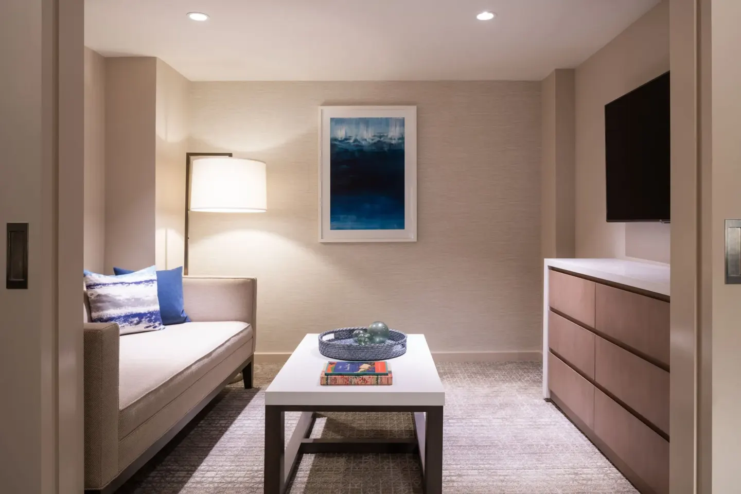 Guest room sitting area with sofa, TV, and coffee table at Sheraton Waikiki Beach Resort.