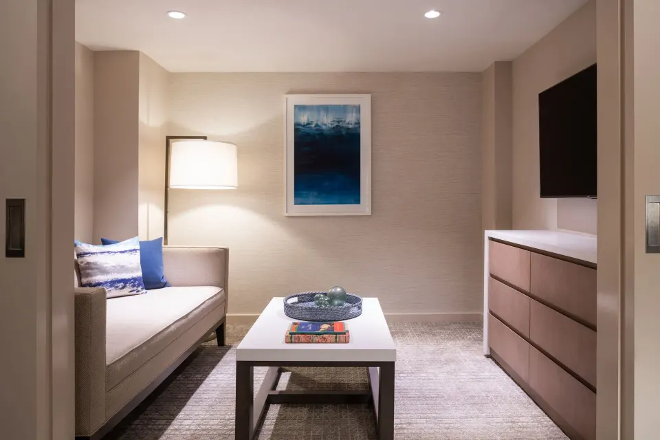 Guest room sitting area with sofa, TV, and coffee table at Sheraton Waikiki Beach Resort.
