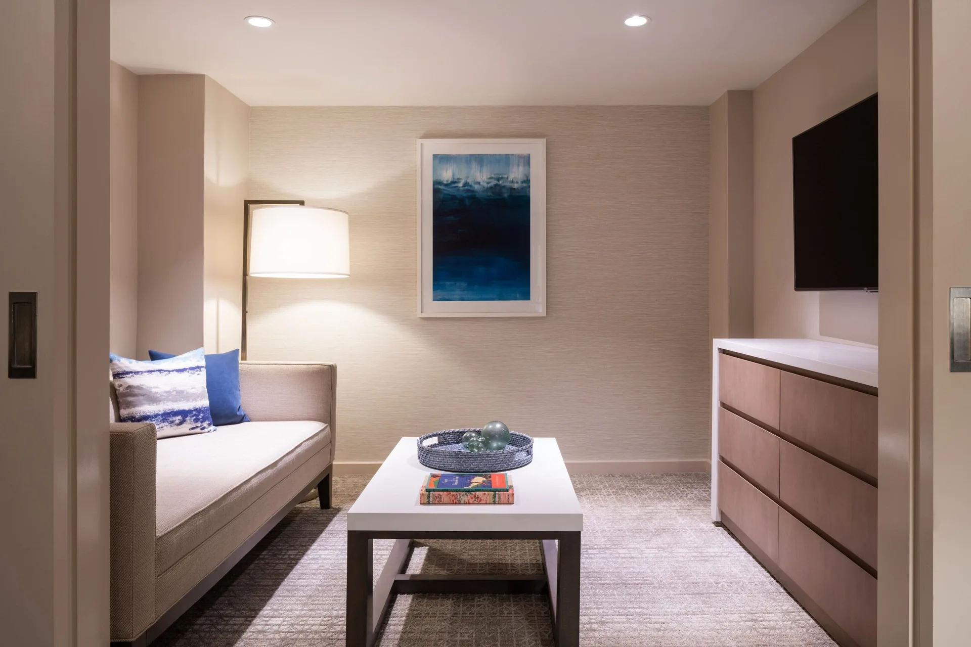 Guest room sitting area with sofa, TV, and coffee table at Sheraton Waikiki Beach Resort.