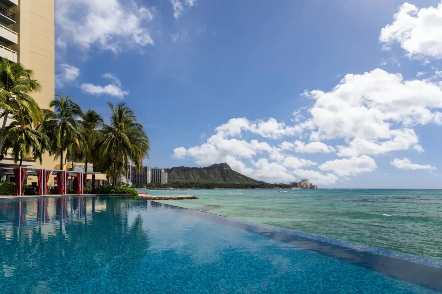 Infinity pool beside the ocean with Diamond Head in the distance at Sheraton Waikiki Beach Resort.