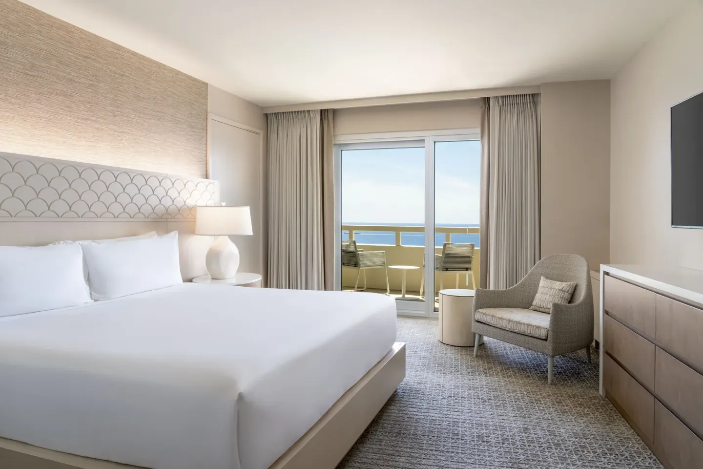 King-bed guest room with ocean-facing balcony at Sheraton Waikiki Beach Resort.