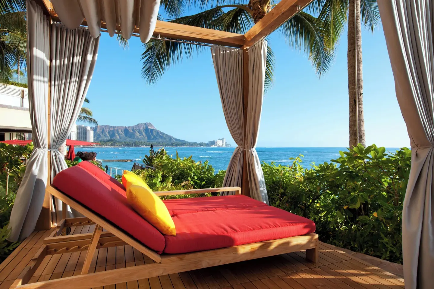 Curtained daybed cabana facing Diamond Head and the ocean at Sheraton Waikiki Beach Resort.