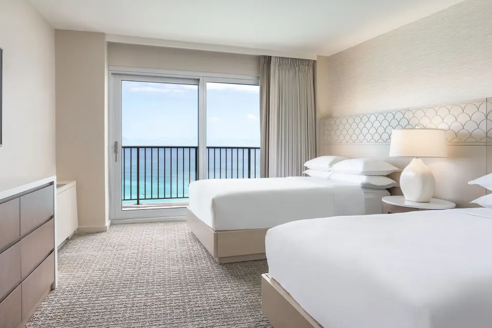 Oceanfront two-bed guest room with balcony at Sheraton Waikiki Beach Resort.