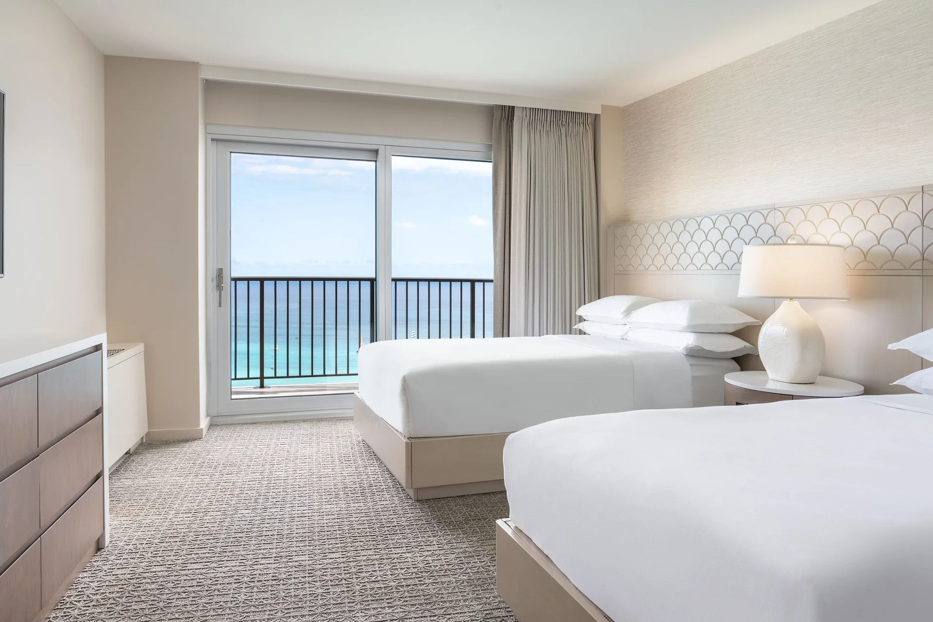 Oceanfront two-bed guest room with balcony at Sheraton Waikiki Beach Resort.