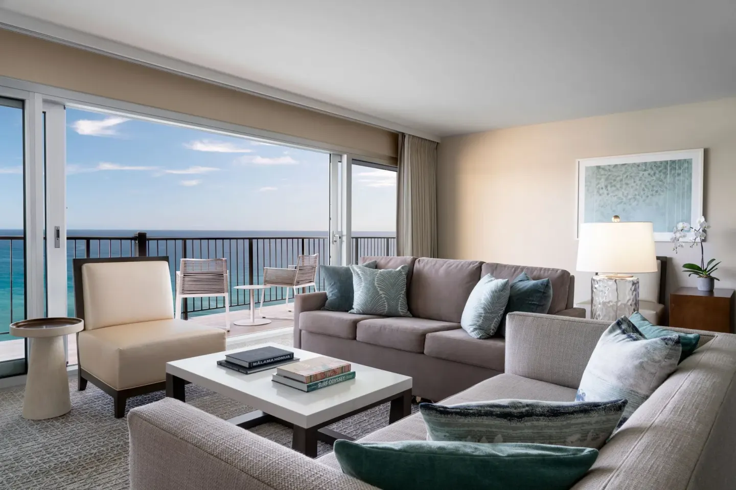 Living room with sofas and oceanfront balcony at Sheraton Waikiki Beach Resort.