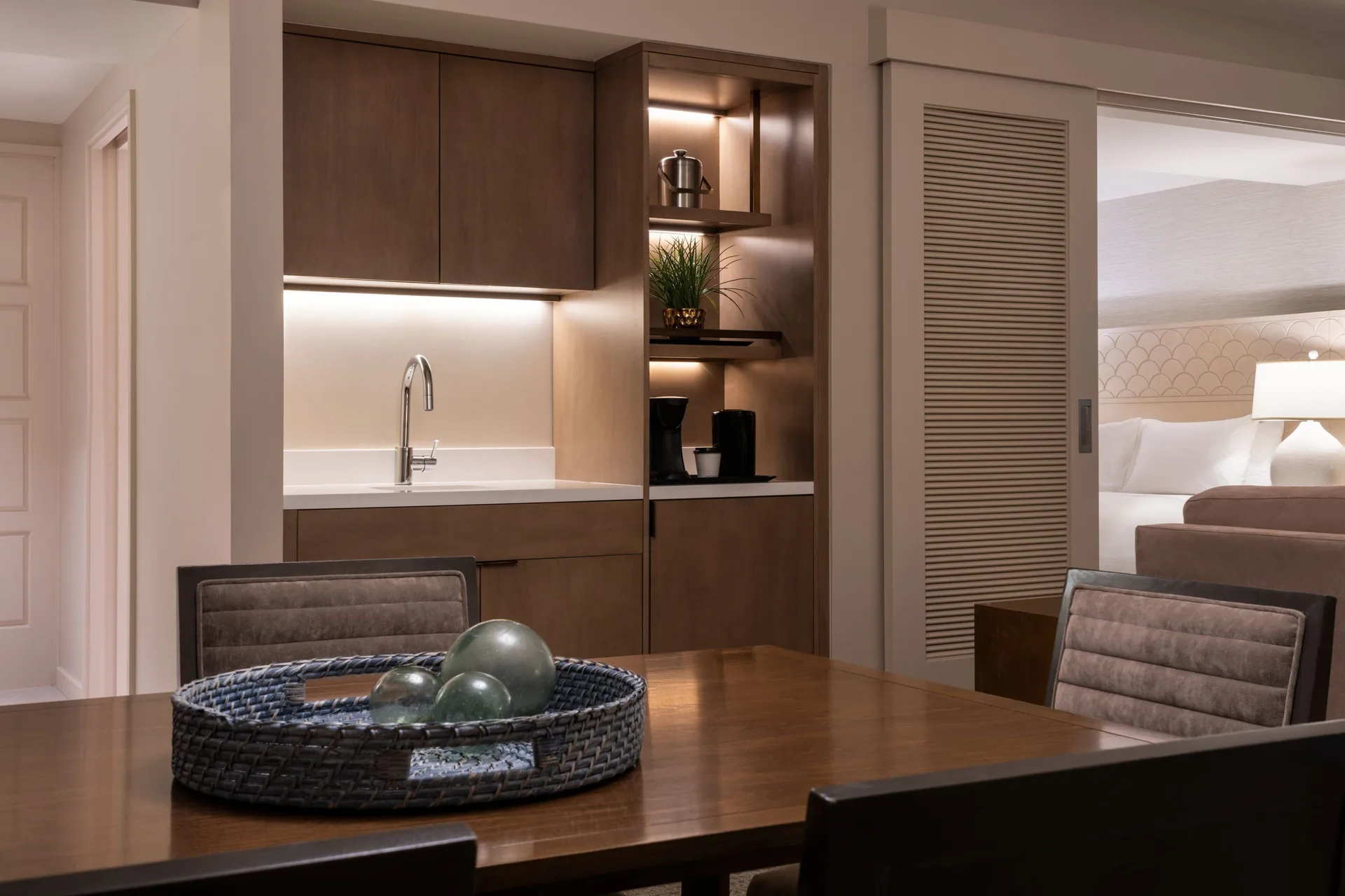Suite dining table and wet bar beside a bedroom at Sheraton Waikiki Beach Resort.