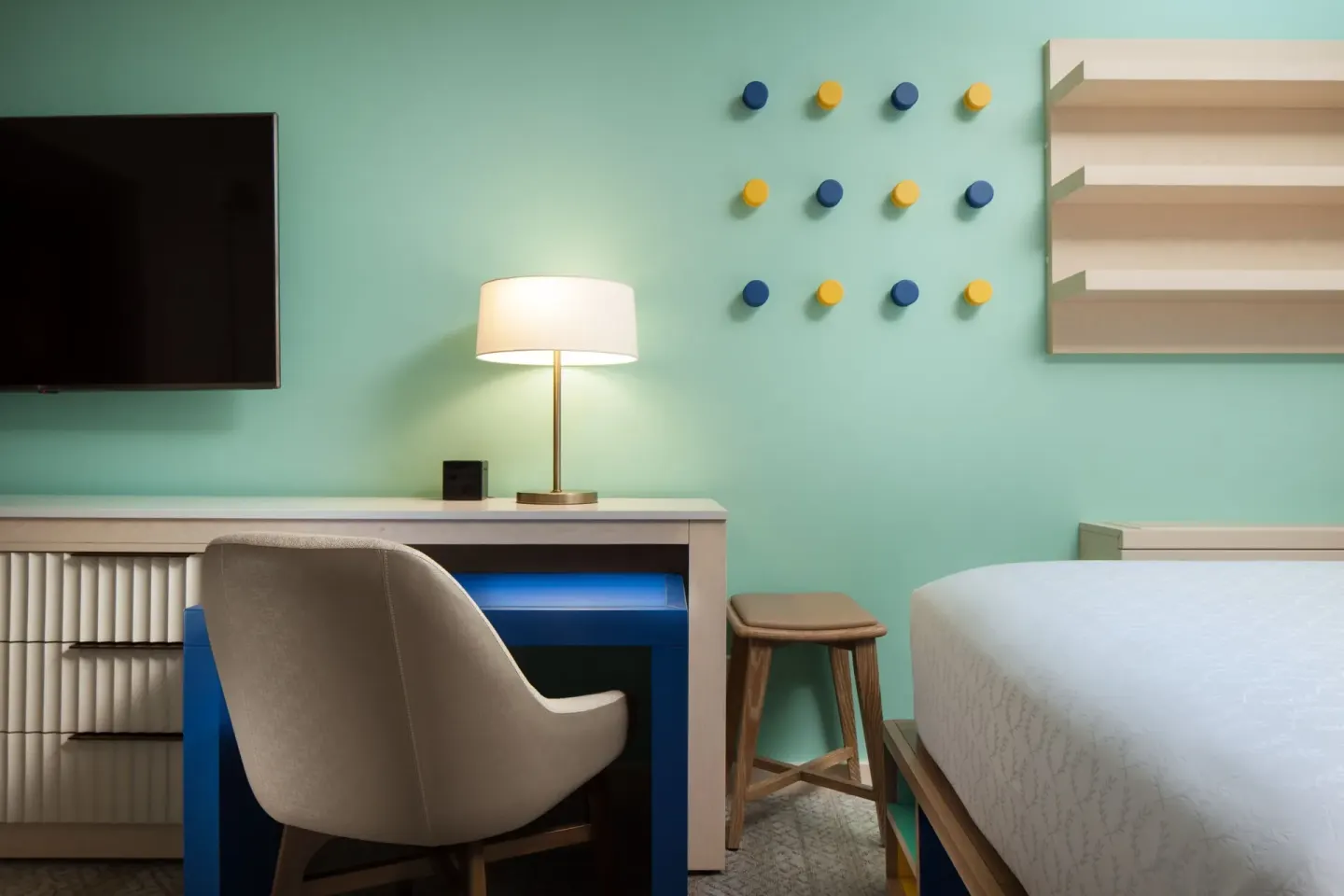 Desk, TV, and bed detail in a family room at Sheraton Waikiki Beach Resort.