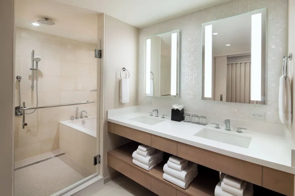 Bathroom with double vanity and glass shower at Sheraton Waikiki Beach Resort.