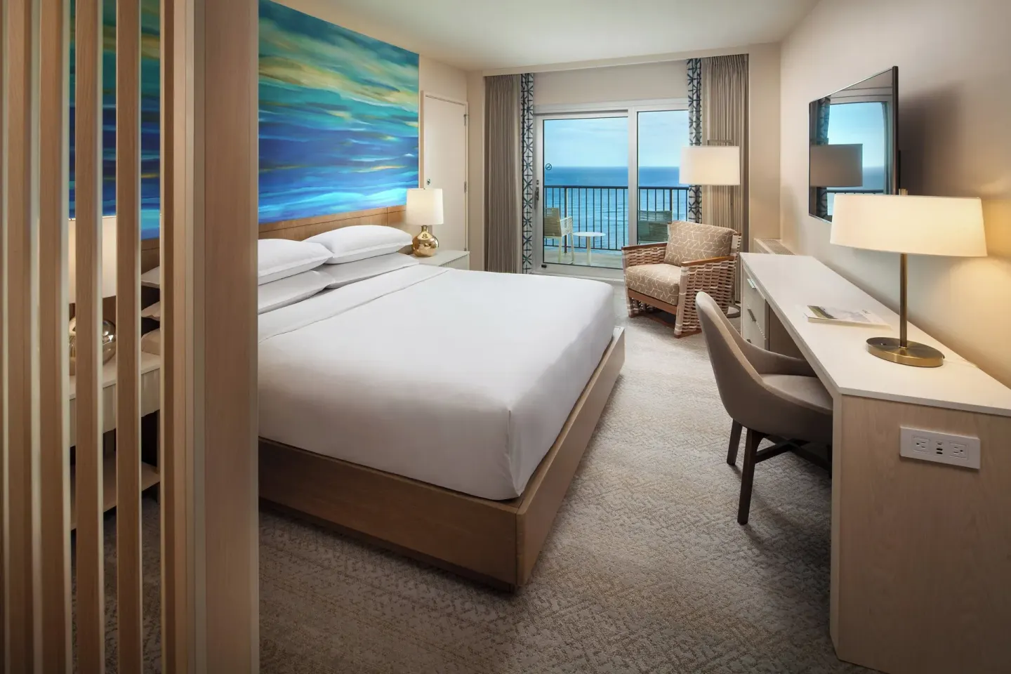 Oceanfront penthouse king guest room with balcony view at Sheraton Waikiki Beach Resort.