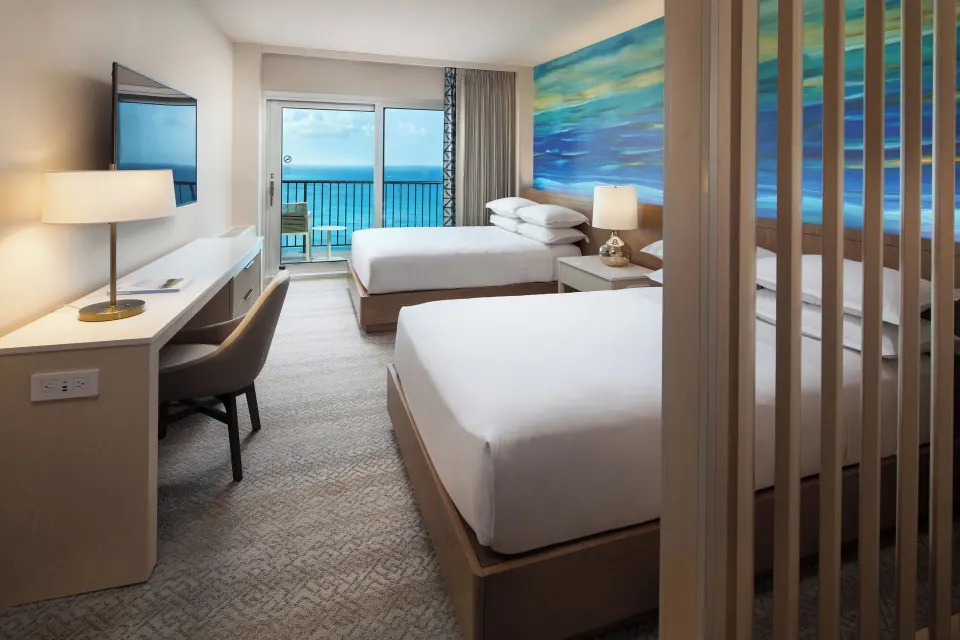 Oceanfront penthouse room with two beds and balcony at Sheraton Waikiki Beach Resort.