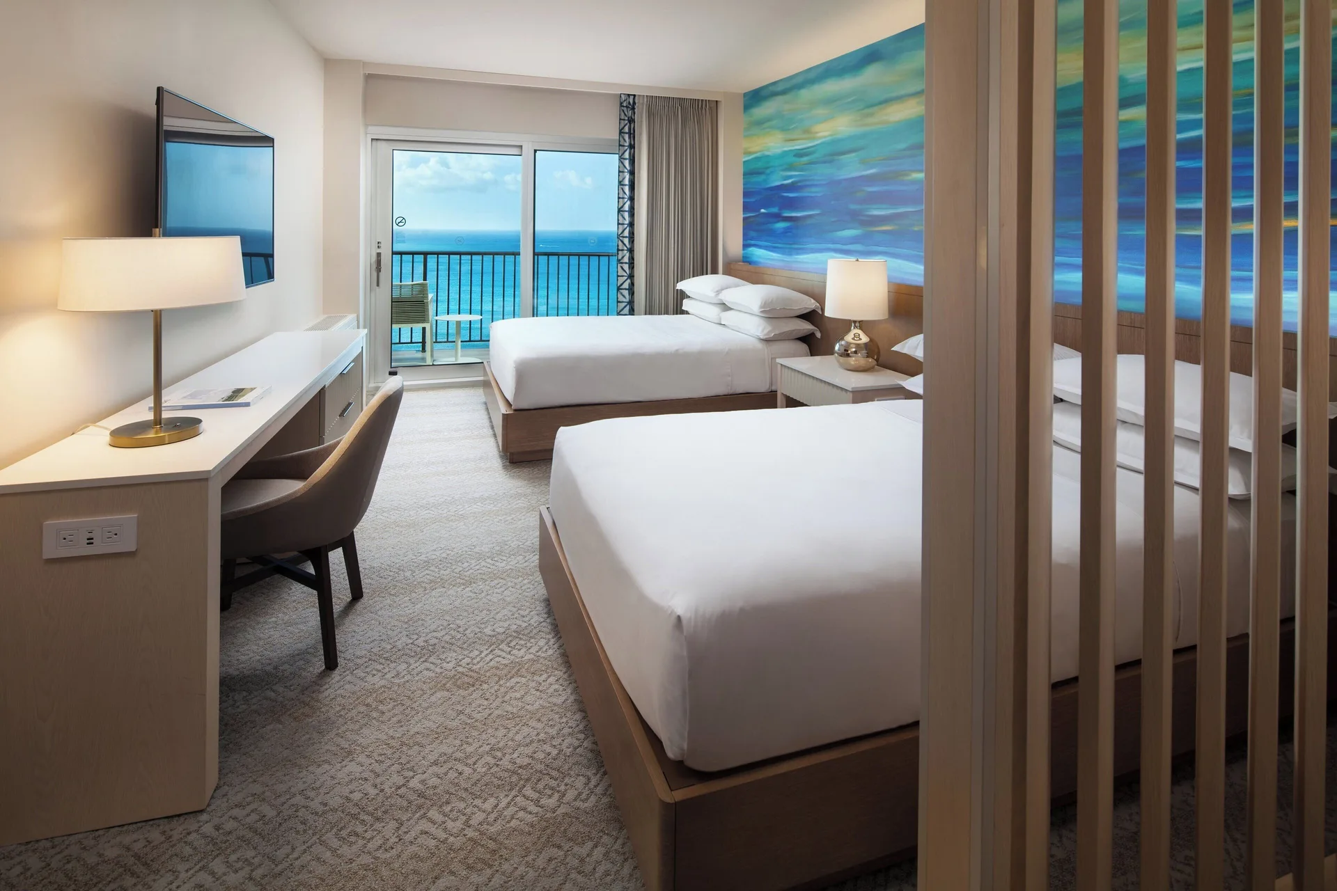 Oceanfront penthouse room with two beds and balcony at Sheraton Waikiki Beach Resort.