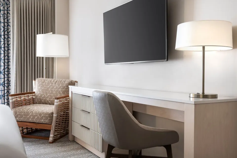 City View room desk, TV, lamps, and armchair at Sheraton Waikiki Beach Resort.