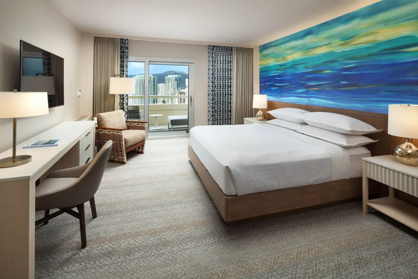 King-bed City View guest room with desk and balcony at Sheraton Waikiki Beach Resort.